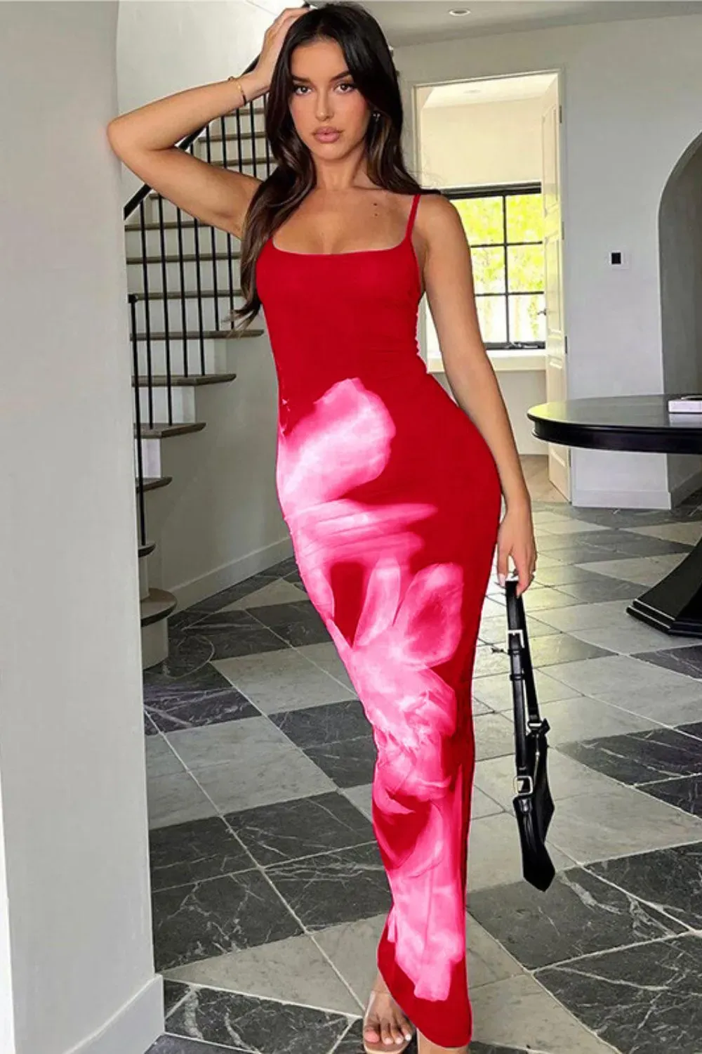 Woman in a red body-hugging dress with artistic floral prints standing in a luxe interior