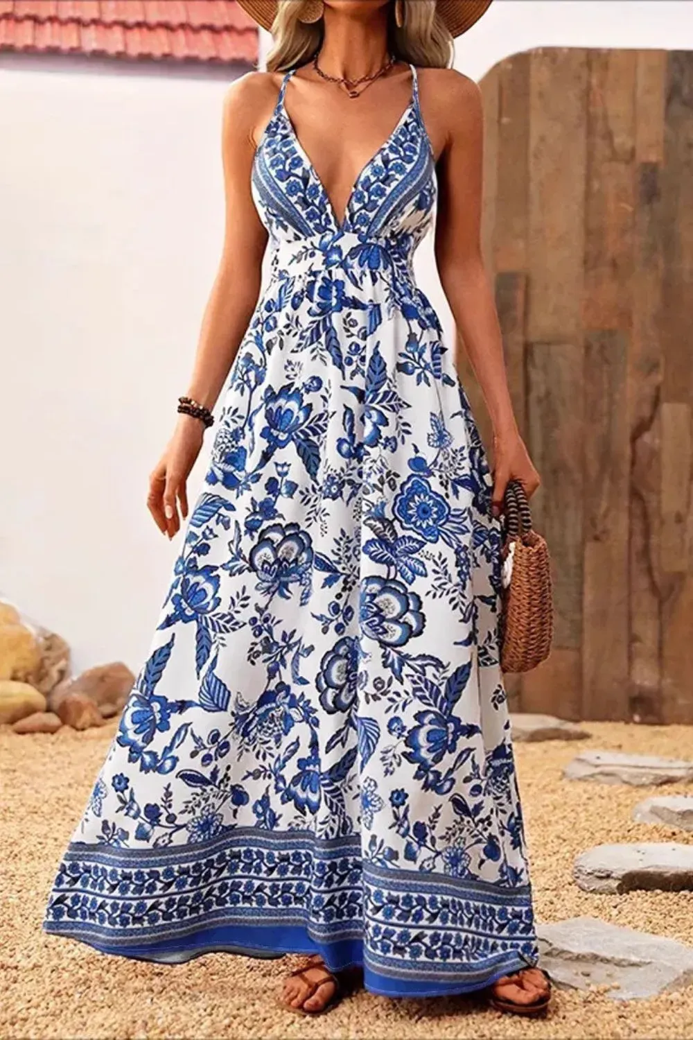 Woman in blue and white floral boho maxi dress with spaghetti straps.
