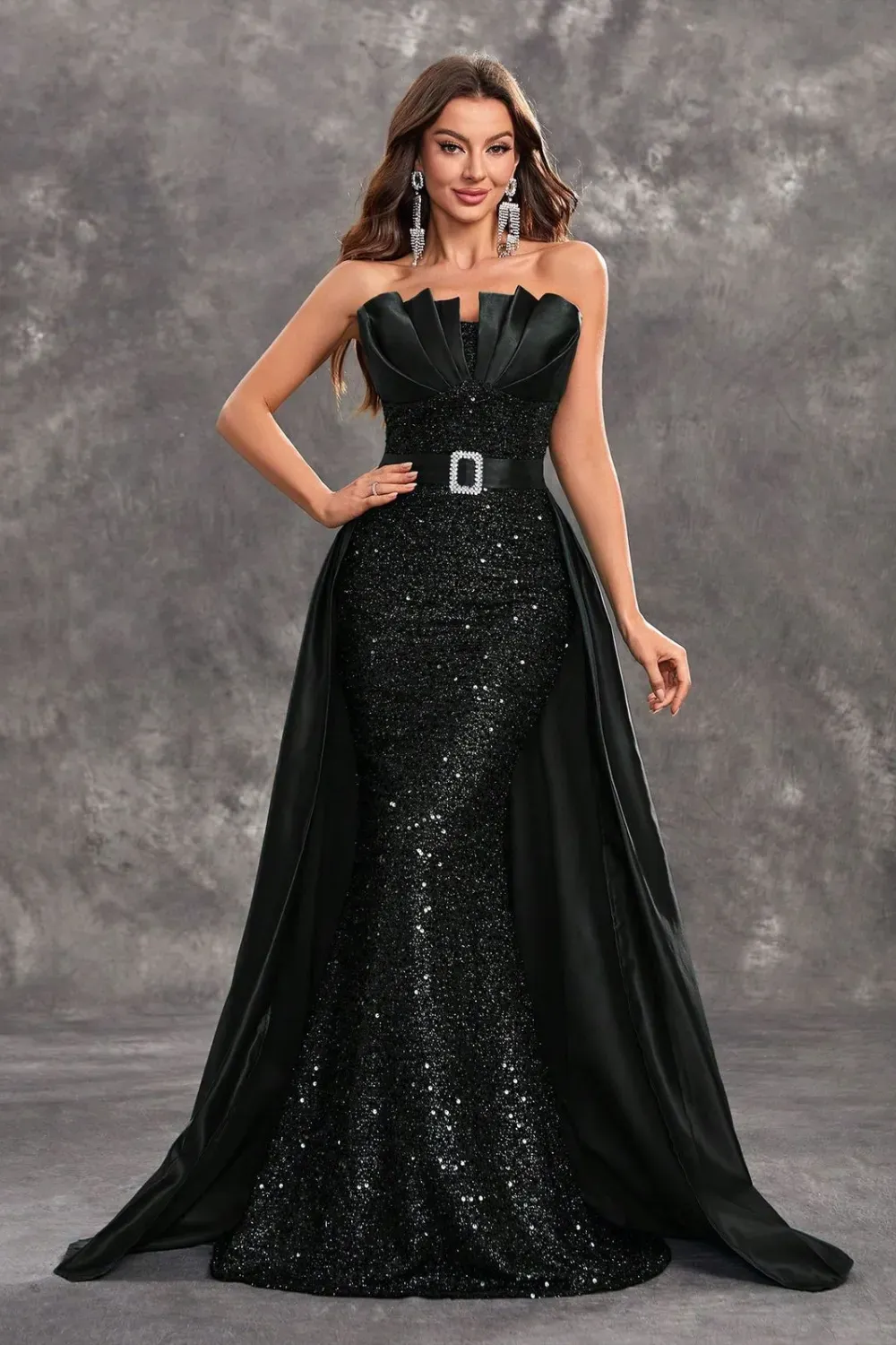 A black sequined gown with a structured bodice, embellished belt, and flowing train, exuding glamour and elegance.