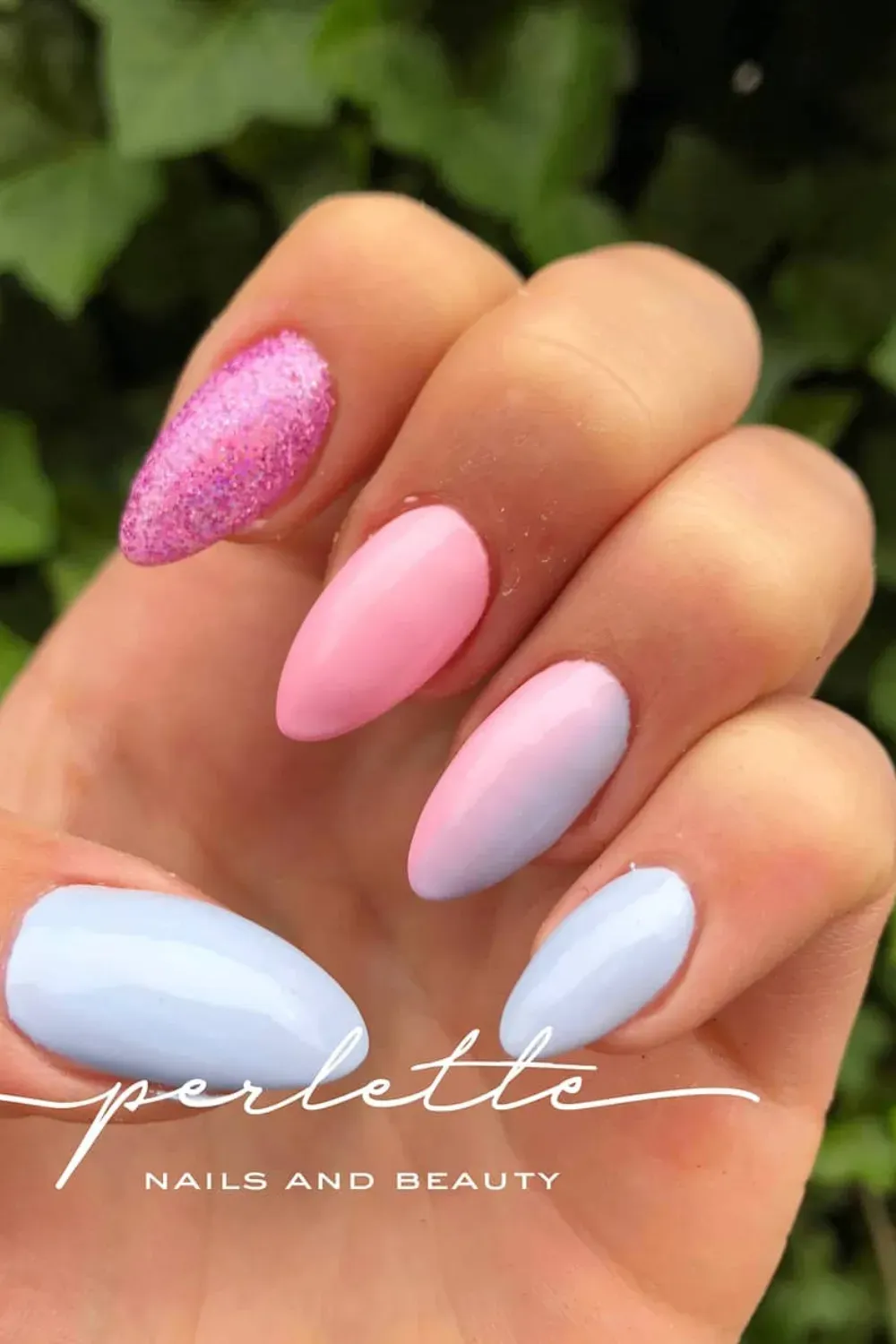 Short pink and blue ombre nails with a glitter accent