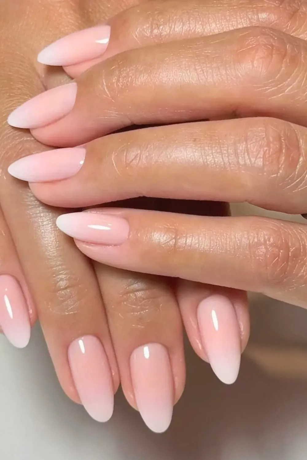 Soft ombre pink nails transitioning from light pink to white for a romantic and elegant effect