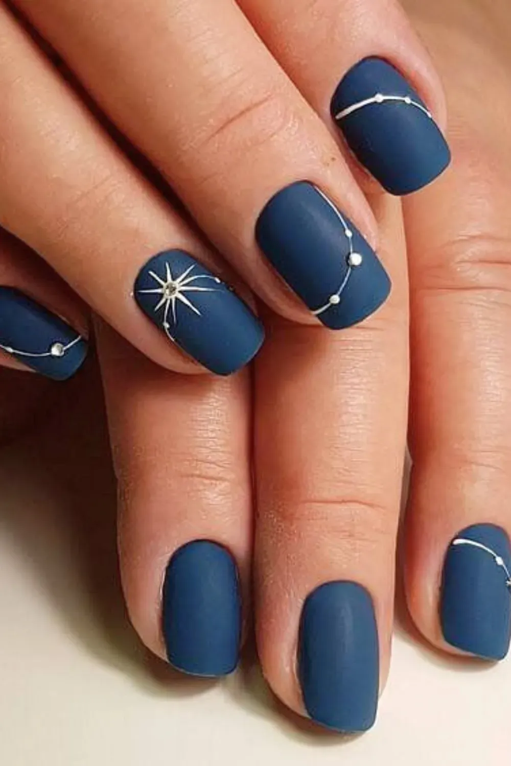 Starry Night Nails - Stunning starry night nails with a cosmic design featuring dark blues and sparkling accents.
