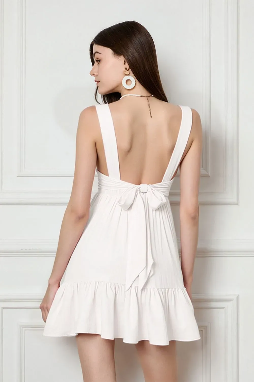 Sweetheart White Mini Dress – Front & Back Bow Detail - Woman wearing white mini dress with sweetheart neckline and back bow detail