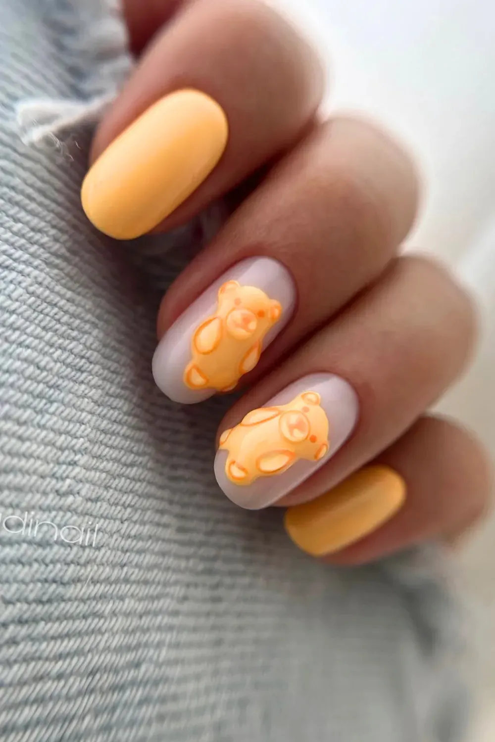 Pastel yellow and white nails with an adorable bear design for a cute back-to-school look