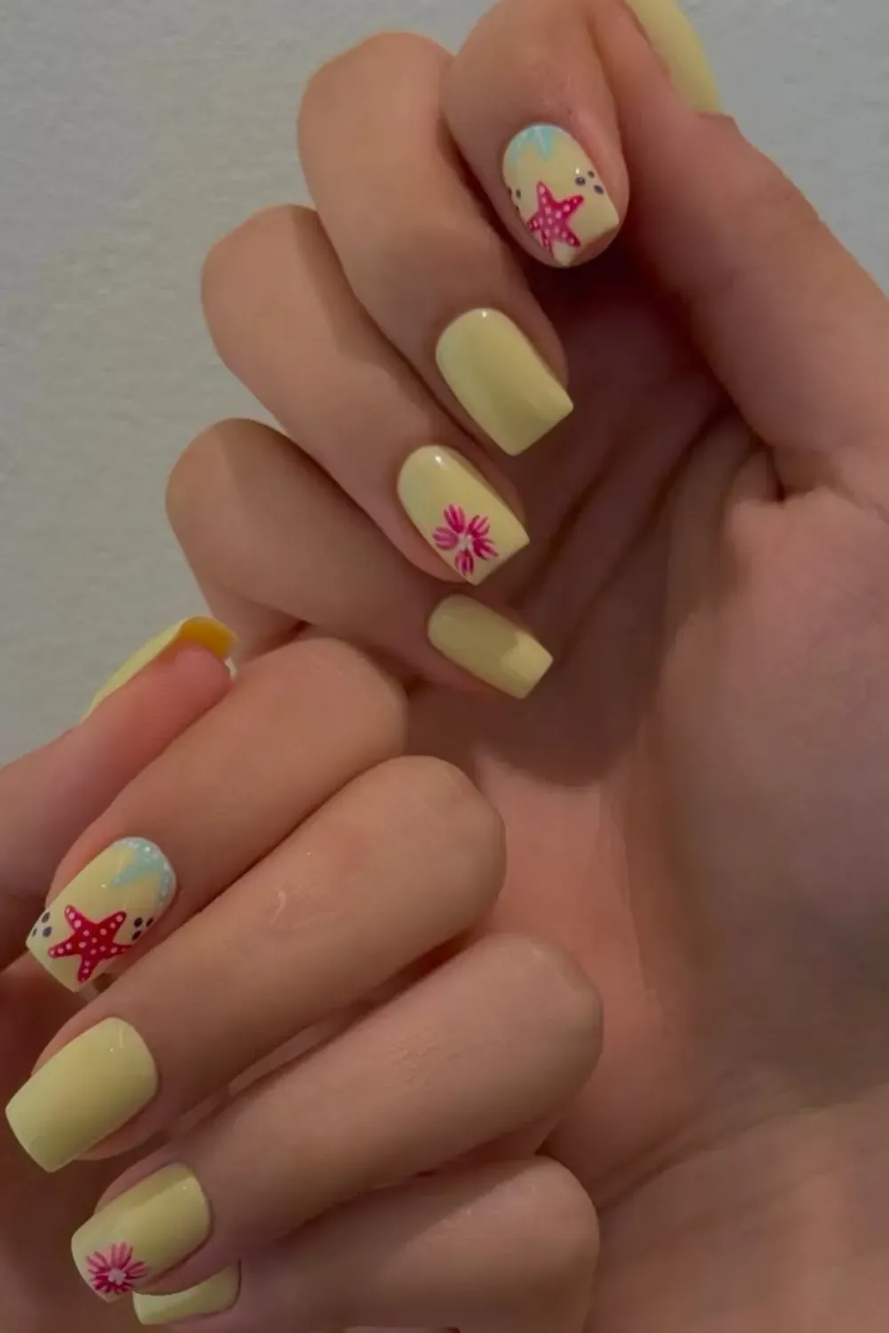 Tropical Yellow Starfish Nails for a Beachy Vibe - Bright yellow nails with starfish and floral designs for a fun and playful beach-inspired look