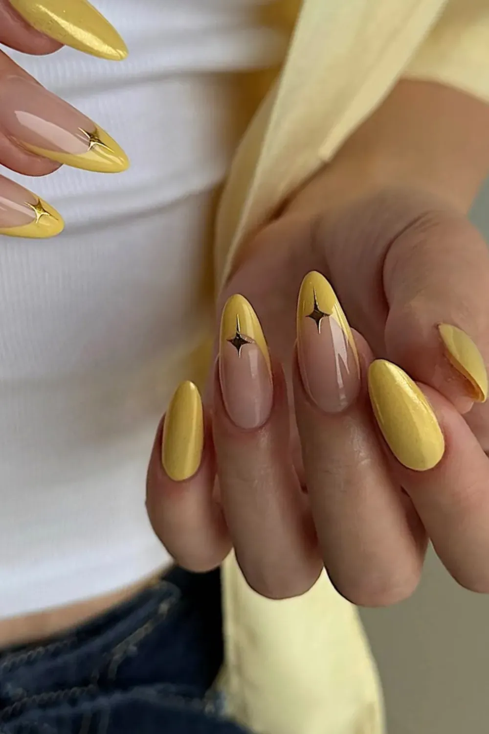 Yellow French tips with star details on a neutral base.
