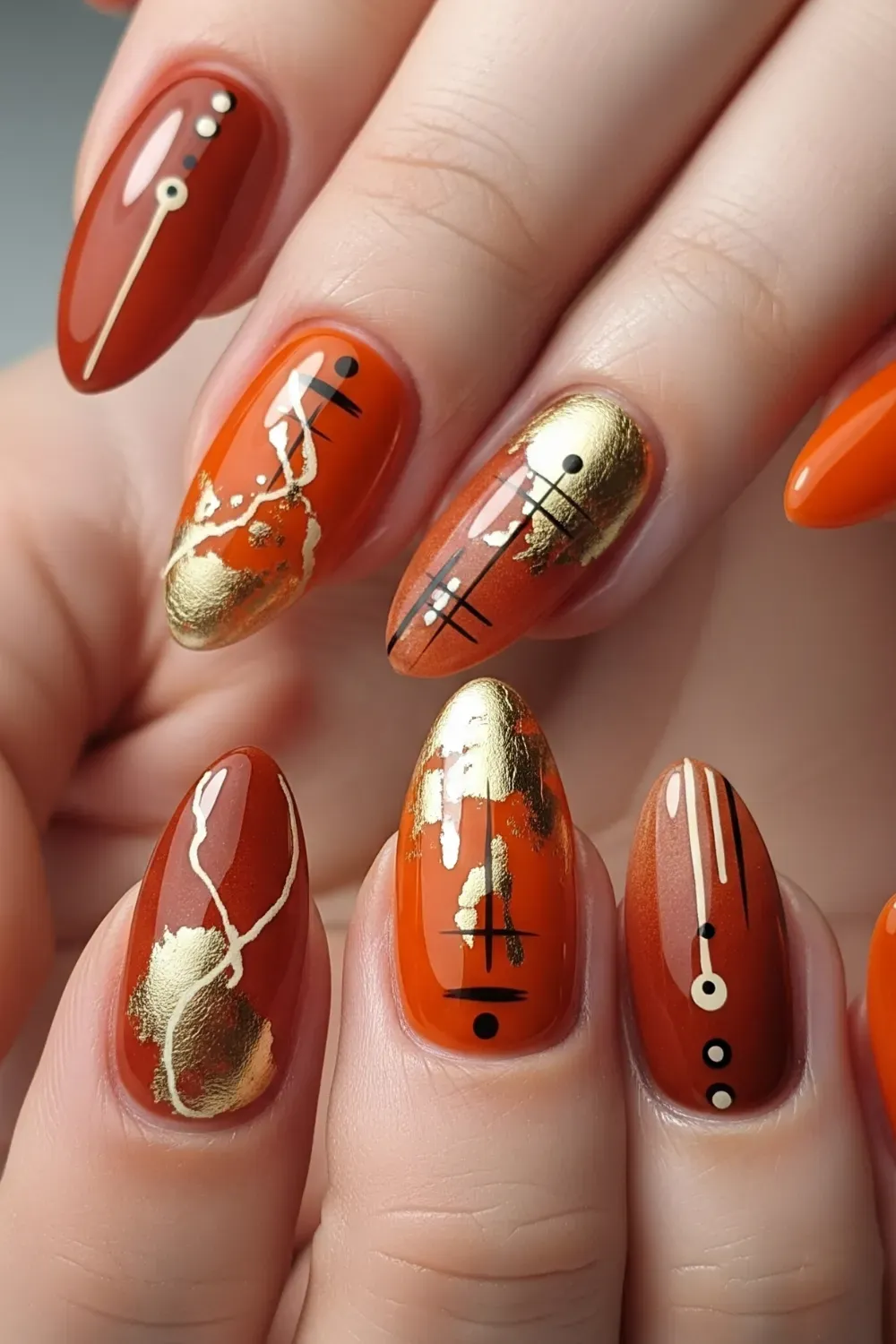 Abstract Orange and Gold Halloween Nails - Artistic orange and gold abstract designs with black dots on Halloween-inspired nails