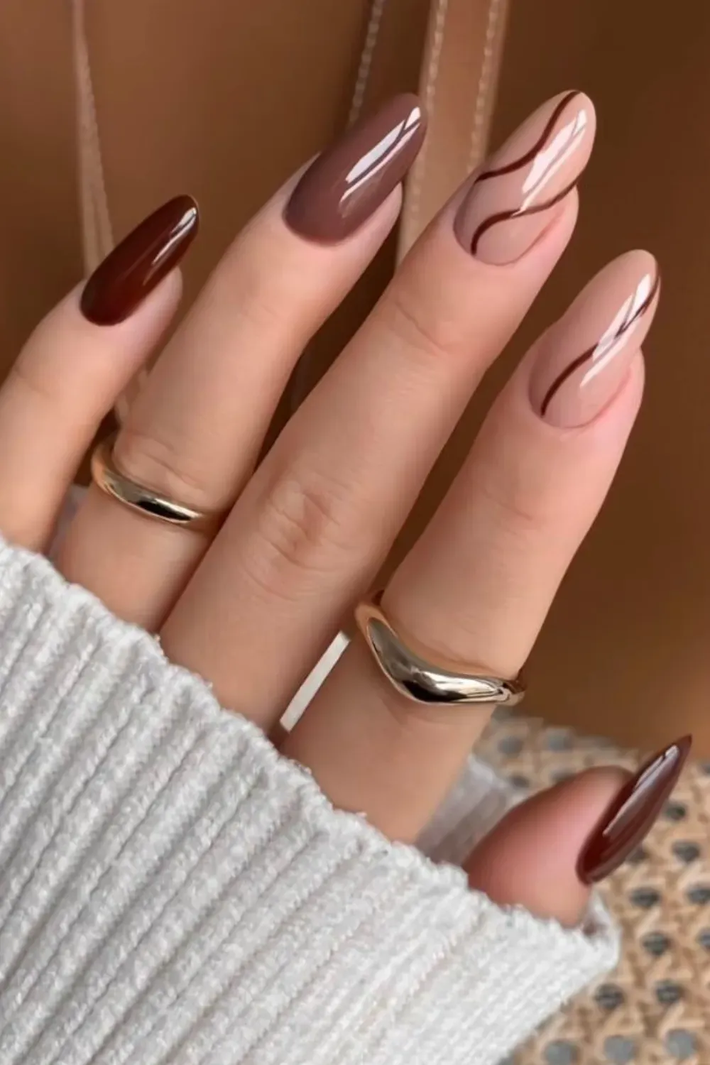  Elegant fall nail art with brown and nude tones, featuring abstract lines for a stylish and modern manicure