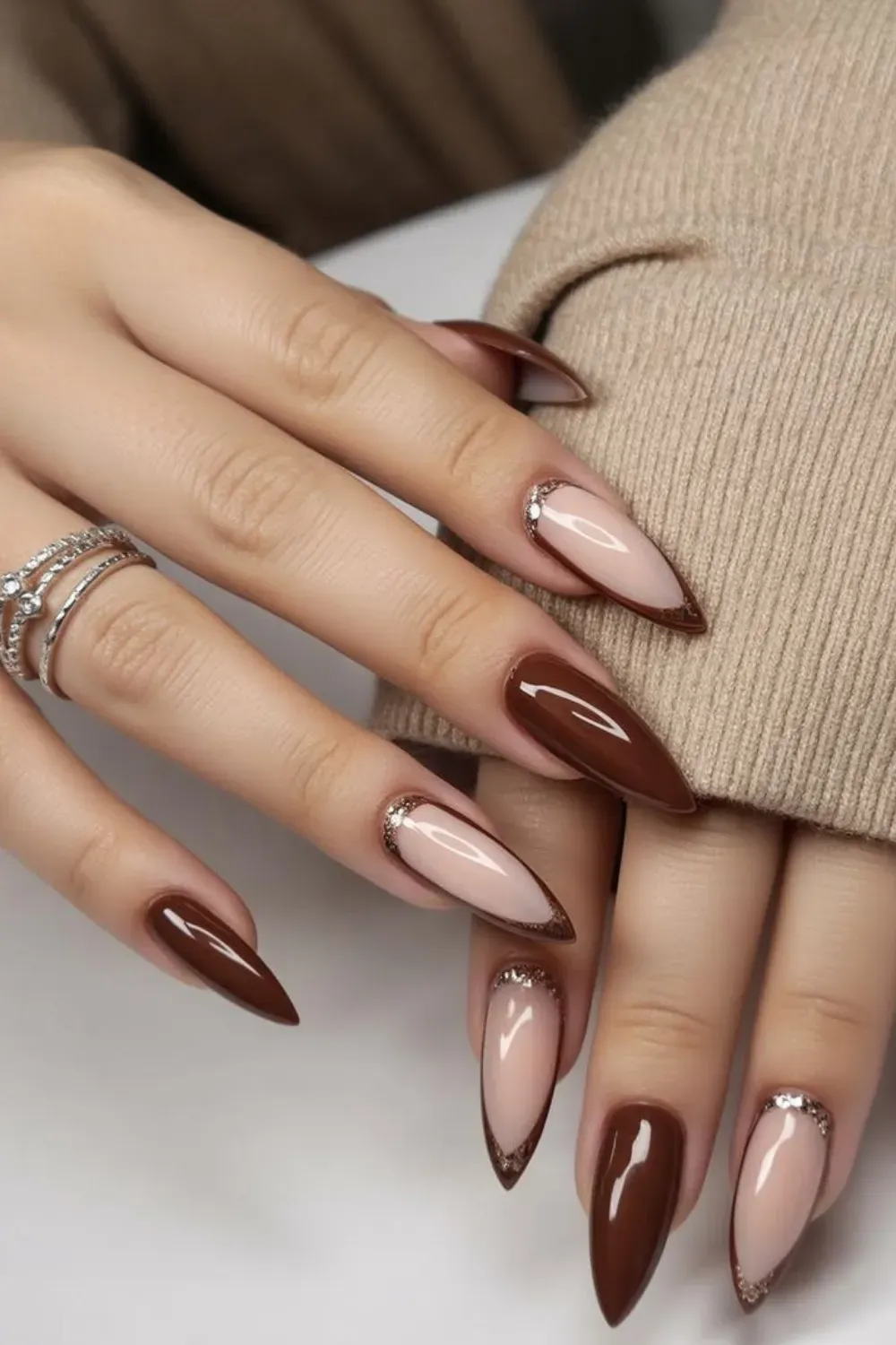 Elegant brown and nude stiletto nails with crystal accents, featuring a sleek and polished gradient design