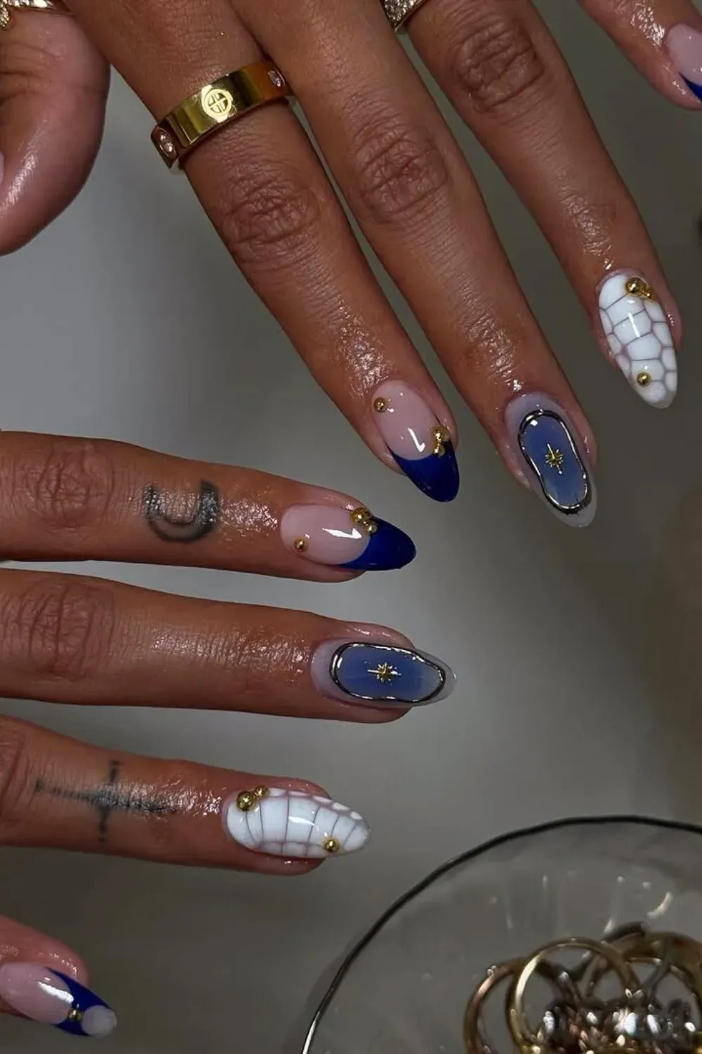 Classic Blue and Metallic Accents – Dark blue nails with metallic line designs.