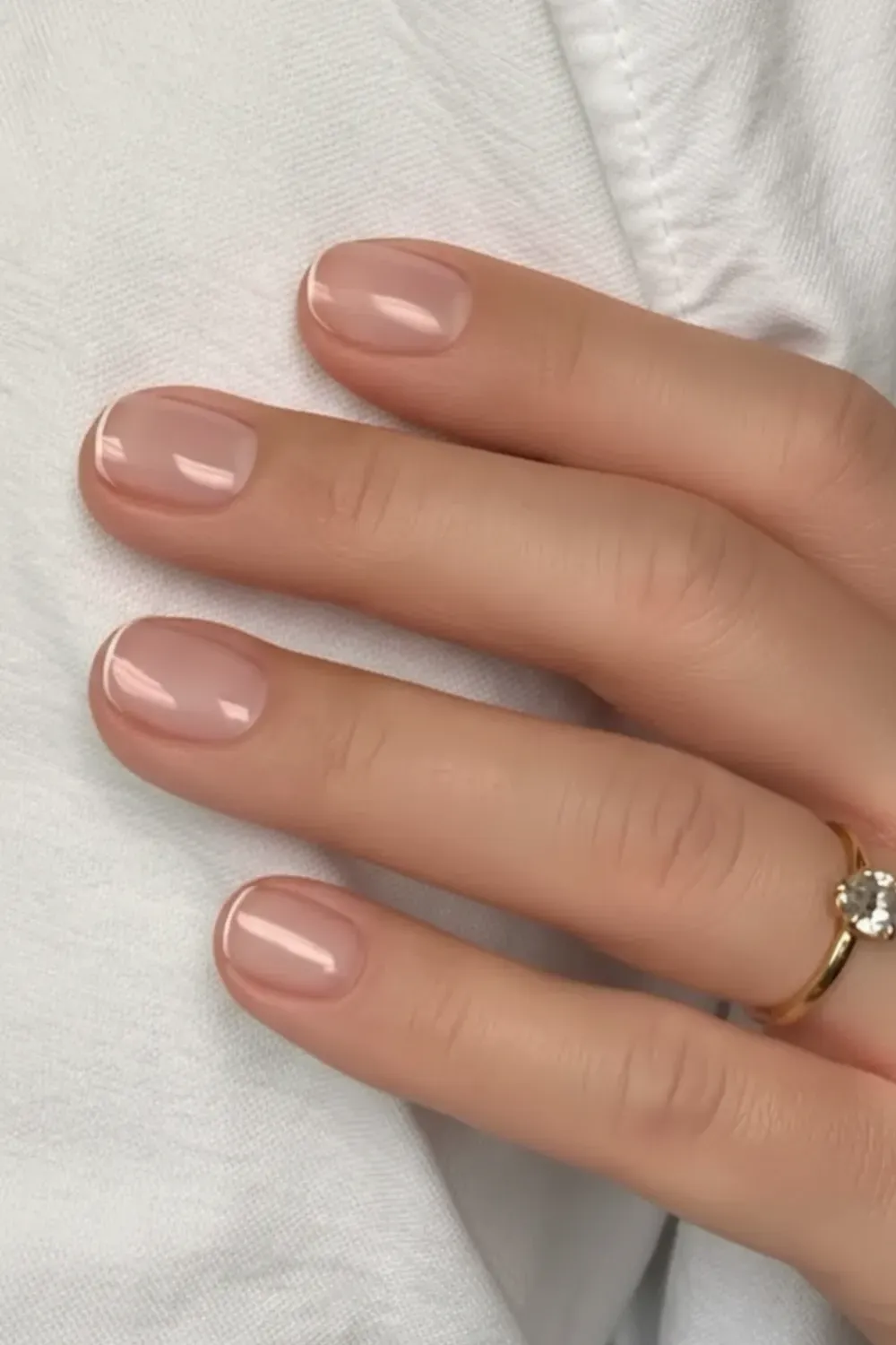 Short nude nails with a glossy finish for a clean and classic look.