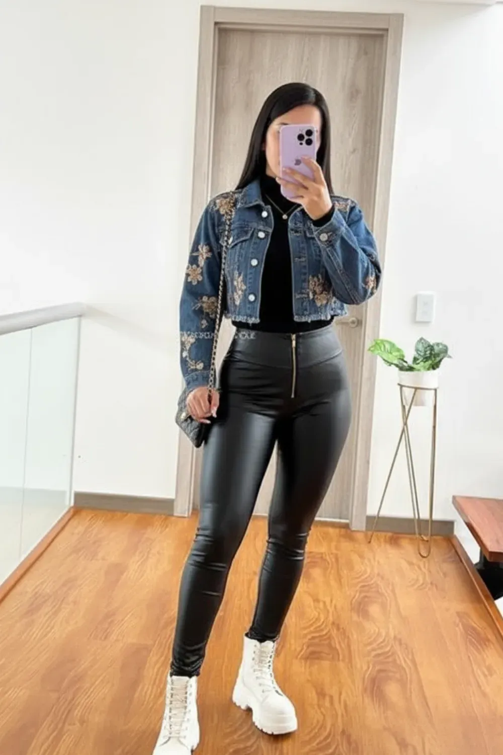 Denim Jacket and Faux Leather Pants - A woman wearing a denim jacket and faux leather leggings, completing the fall look with white sneakers.