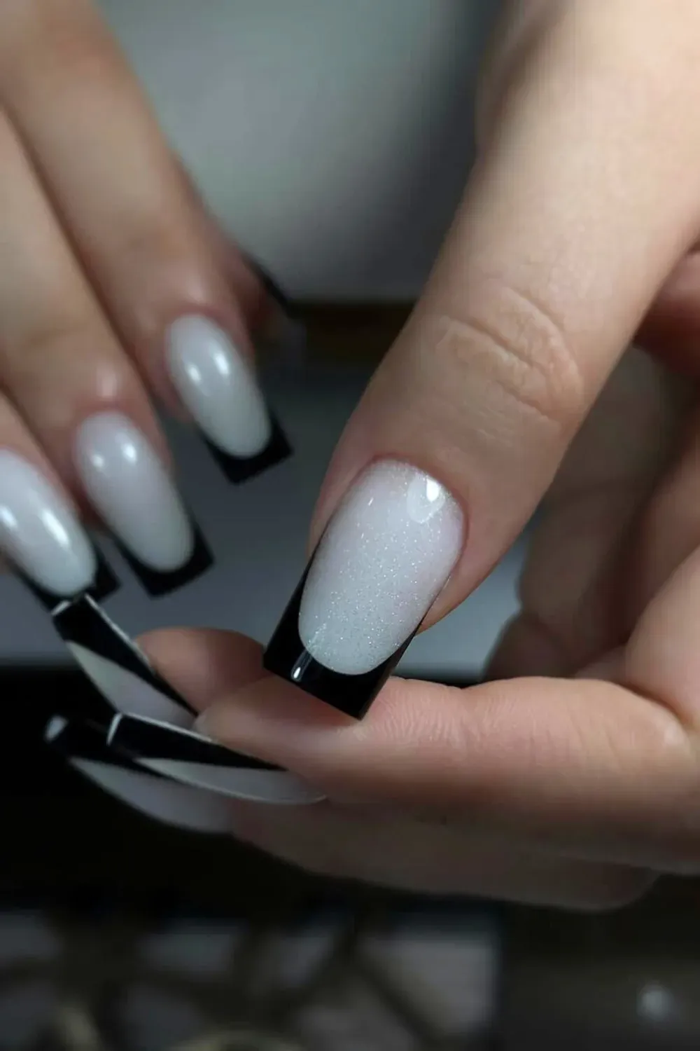 Black French tips with a shimmering silver metallic finish, creating an elegant and sophisticated design.