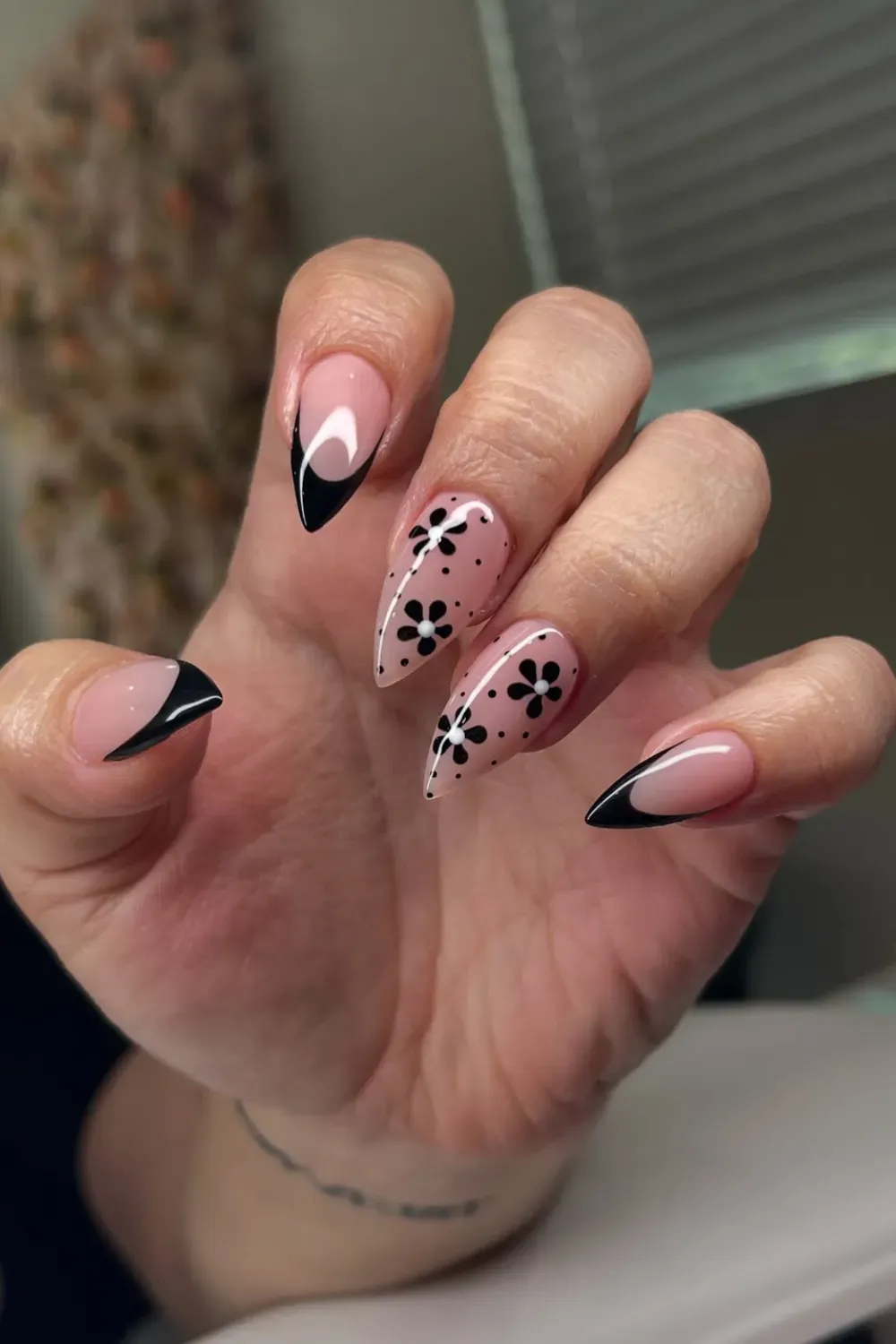 Floral Nails with Black Accents - A stylish manicure featuring soft pink nails with black floral designs and black tips