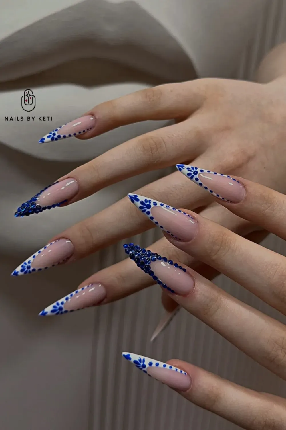 Floral and Crystal Accents – Dark blue nails with floral designs and crystal embellishments.