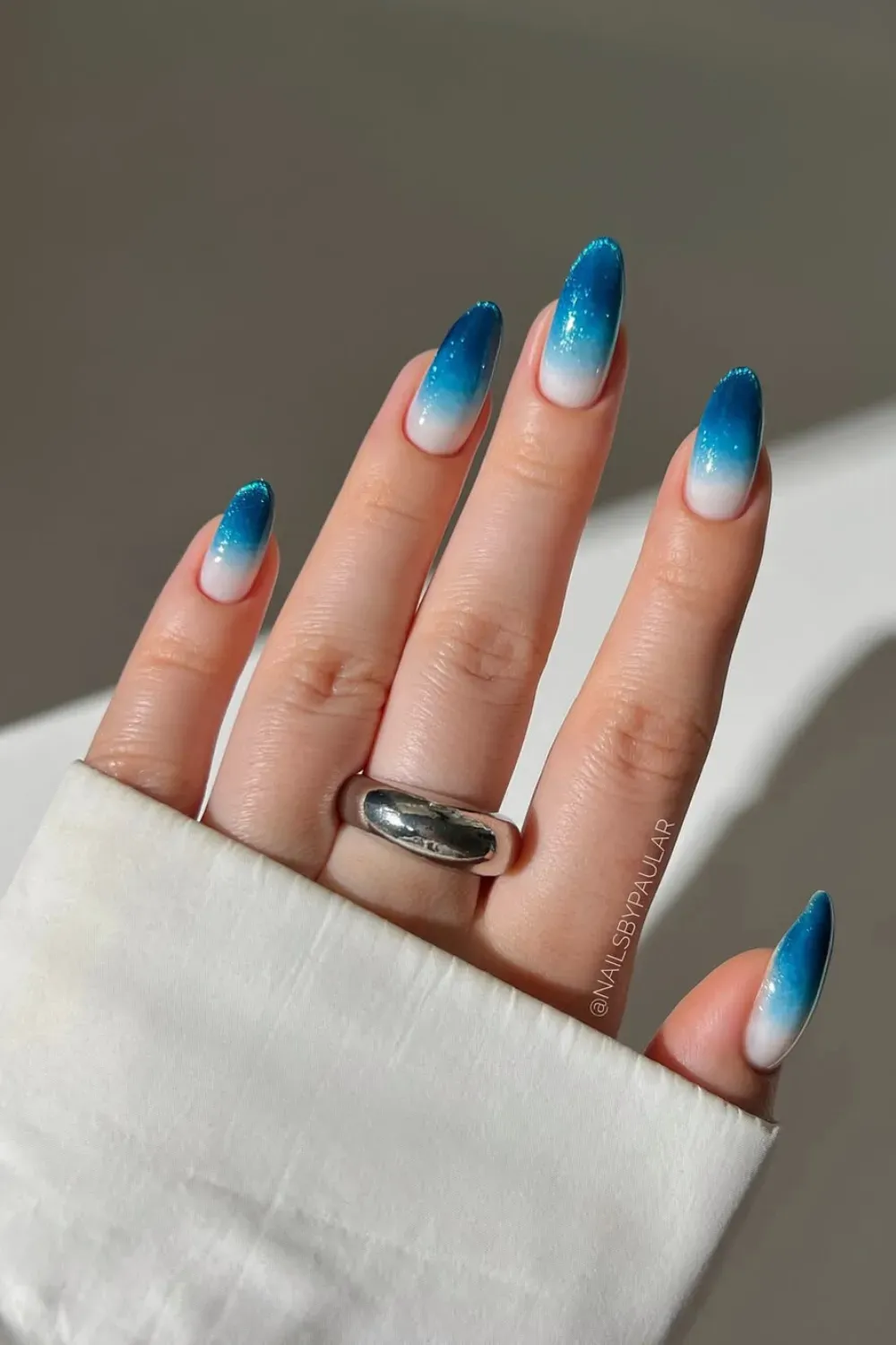 Glittering Blue French Tips – Dark blue French tips with glitter accents.
