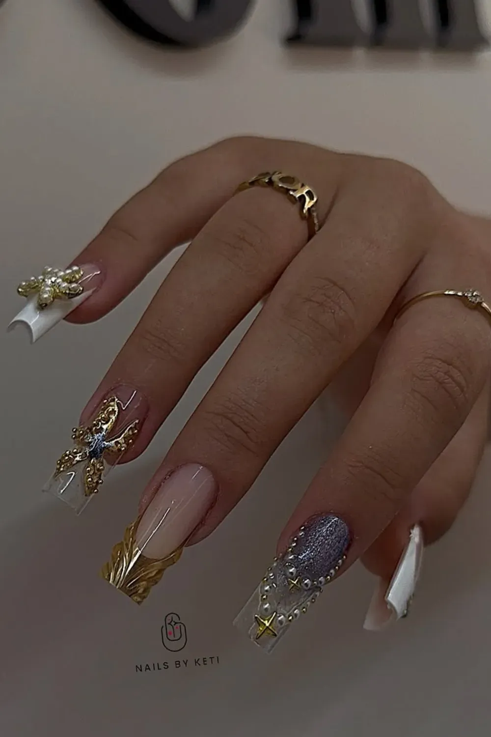 Gold and Pearl Nail Art - A luxurious nail design featuring gold foil and pearl embellishments on a neutral base