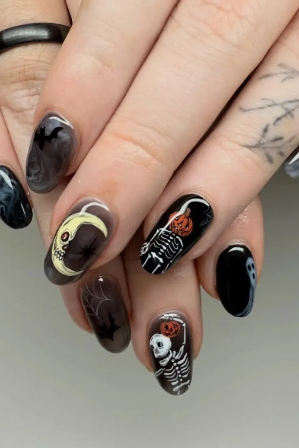 Gothic Skeleton and Ghost Halloween Nail Art - Halloween-themed nail art with skeletons, pumpkins, and ghosts for a spooky vibe.
