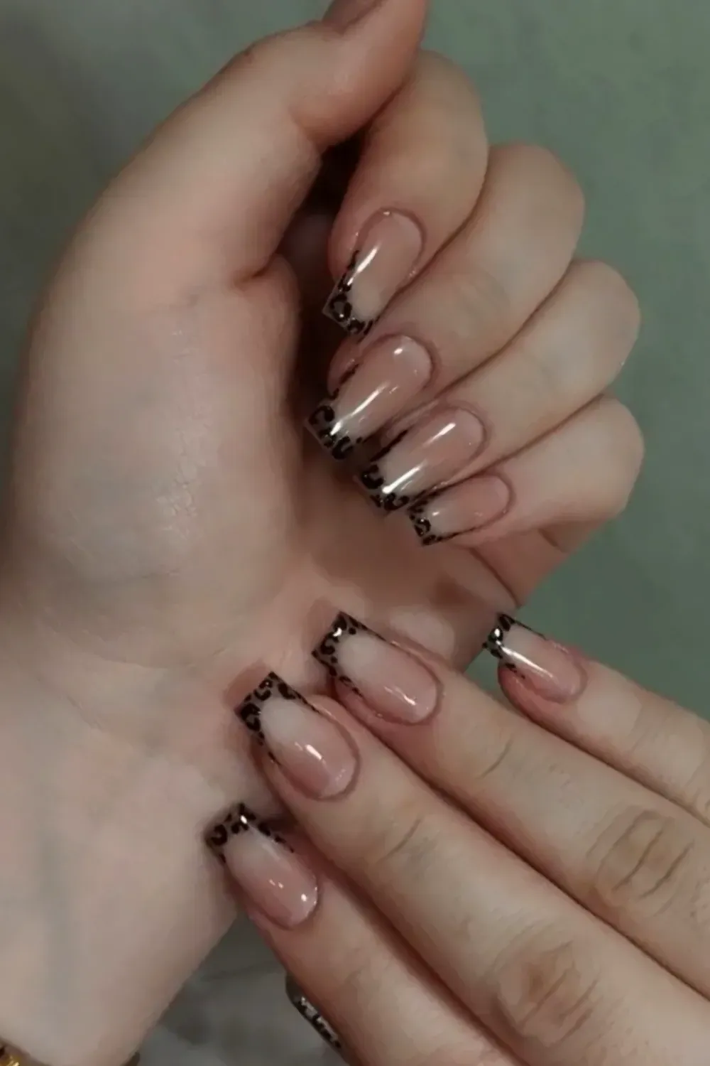 Leopard Print French Tips - Nude nails with bold leopard print at the tips, creating an edgy yet elegant design.