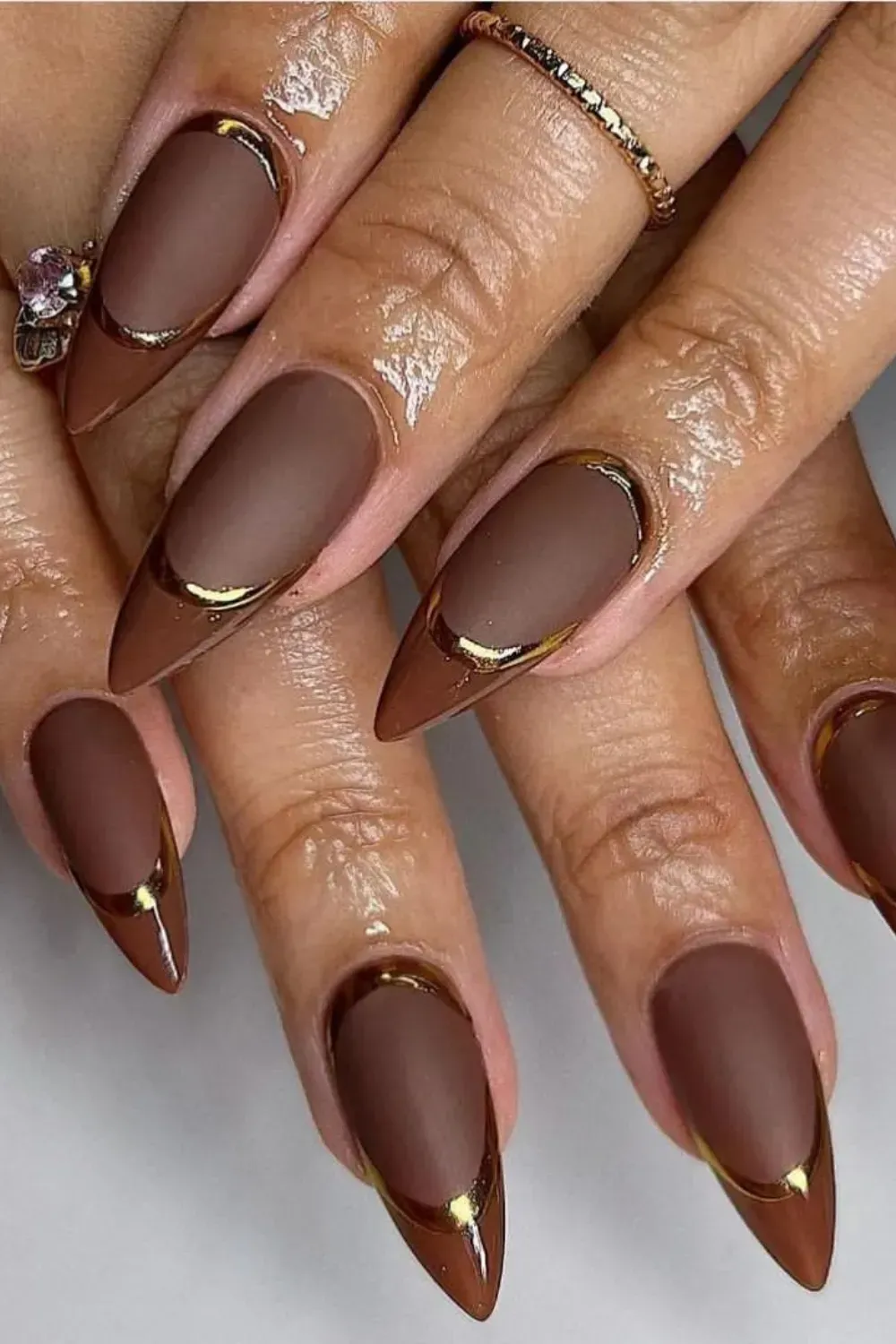 Brown matte and glossy French tip nails with gold accents, featuring a chic fall-inspired design