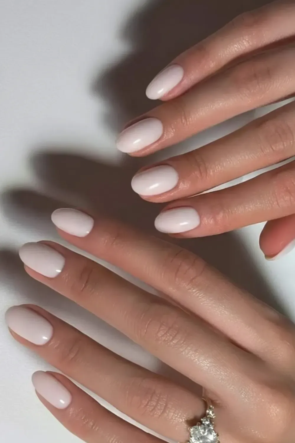  Milky white short nails with a hint of shimmer for a delicate and fresh appearance.