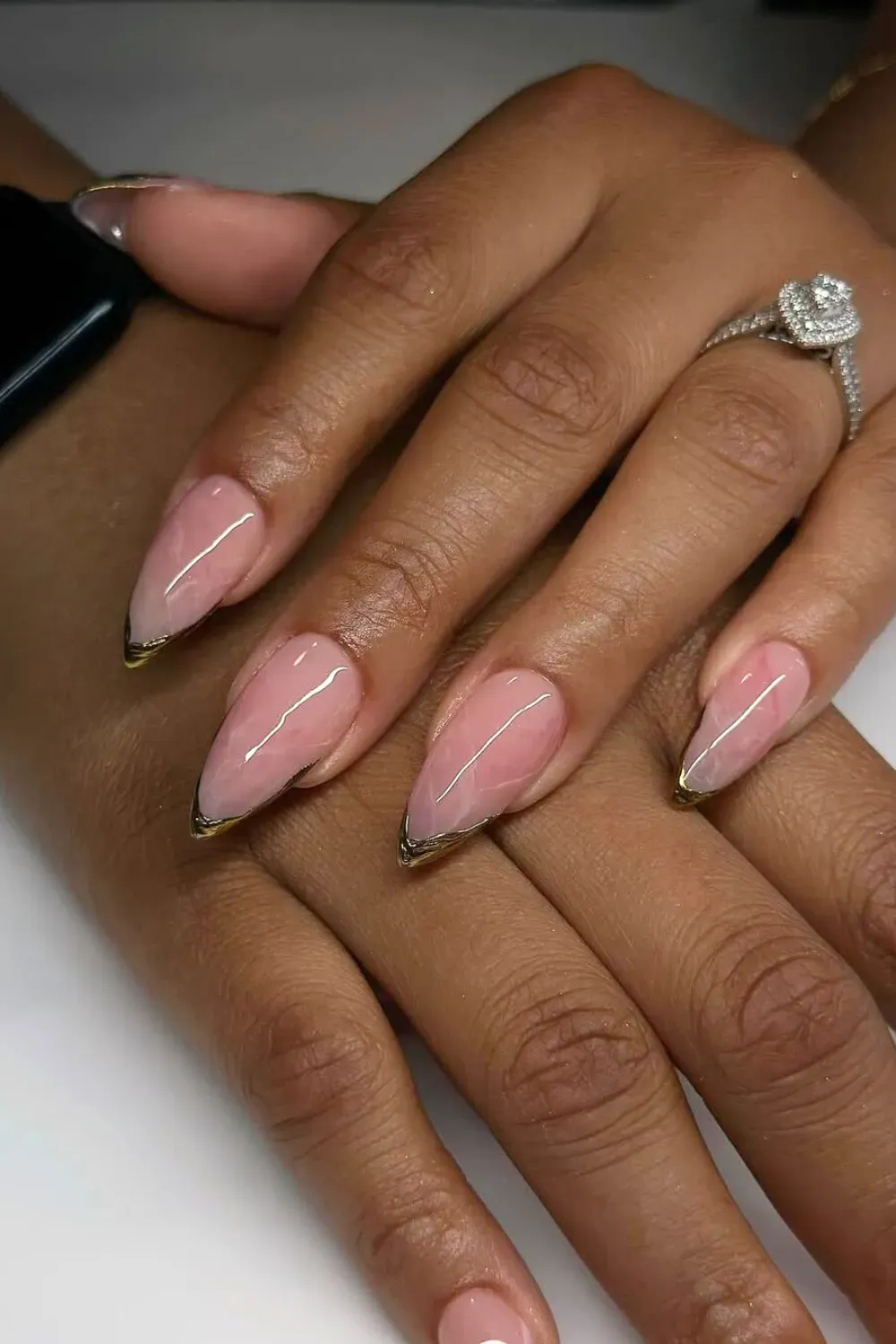 Rose quartz-inspired pink marble French tips with gold accents at the tips, creating a luxurious and elegant nail design.