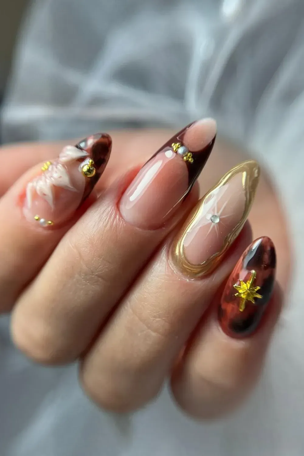 Elegant Marble and Metallic Accents  - Marble and metallic gold nails with delicate gems for a sophisticated fall look