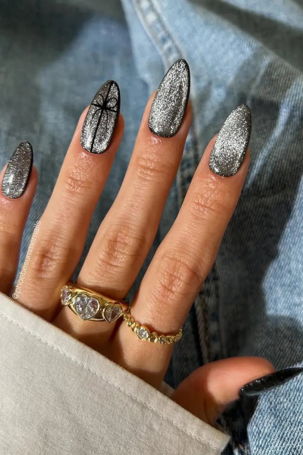 Silver Velvet Chrome Nails with Black Accent	Hands showcasing long silver magnetic velvet chrome nails with a single black accent nail.