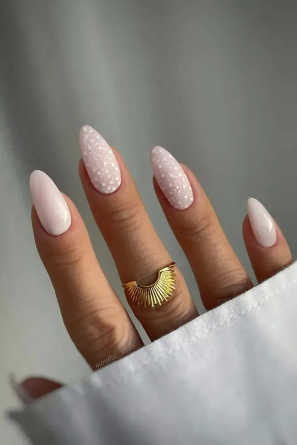 Sophisticated Speckled Milky Pink Accent Nails - Long almond nails with a soft pink milky base, featuring a white speckled/polka dot design on the ring and middle fingers.