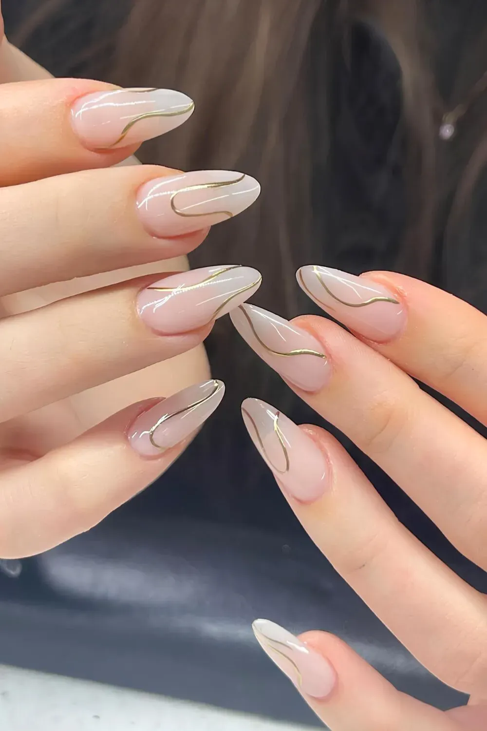 Almond nails with abstract gold line art.