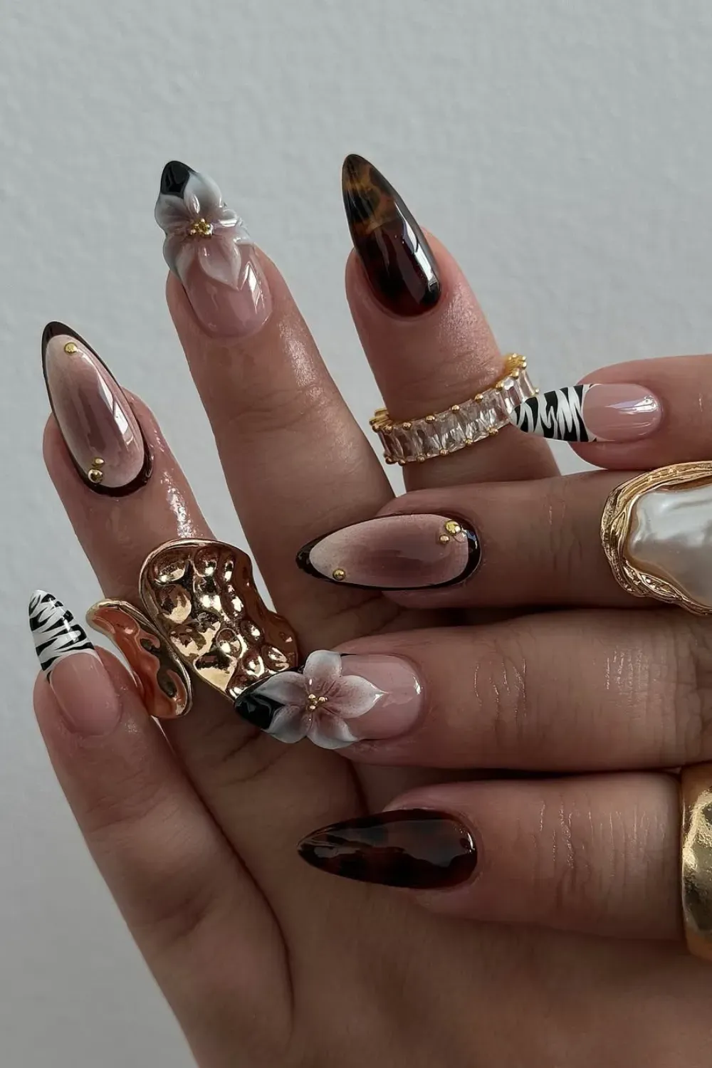 Maximalist Animal Print 3D Mix-and-Match - A complex mix-and-match set featuring tortoiseshell, zebra print, a 3D butterfly charm, and sculptural acrylic flowers on long stiletto nails.