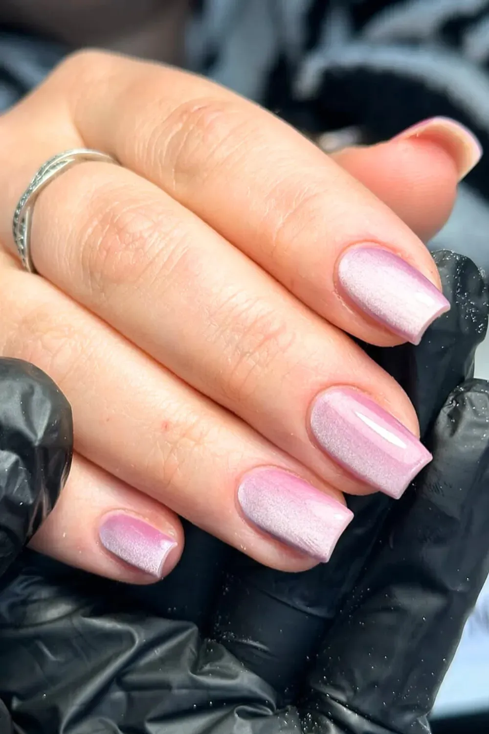 Subtle baby pink cat eye nails with a pearlescent white shimmer on a short, square nail shape.
