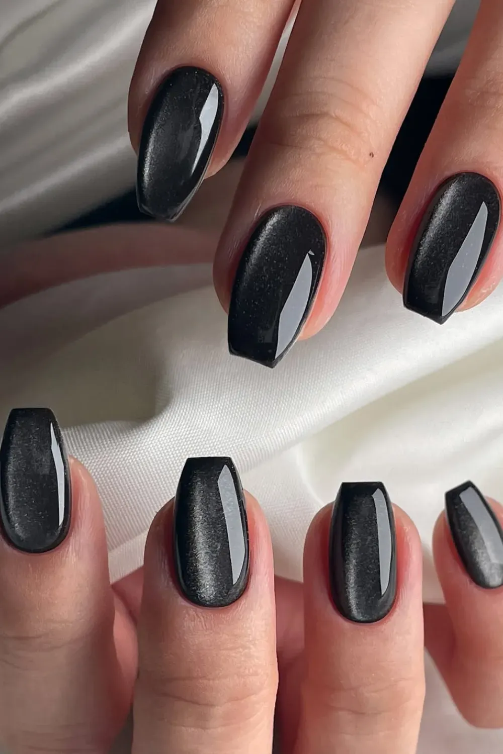 Close-up of square-coffin nails with a black magnetic (cat-eye) polish, showing a central shimmering light line.