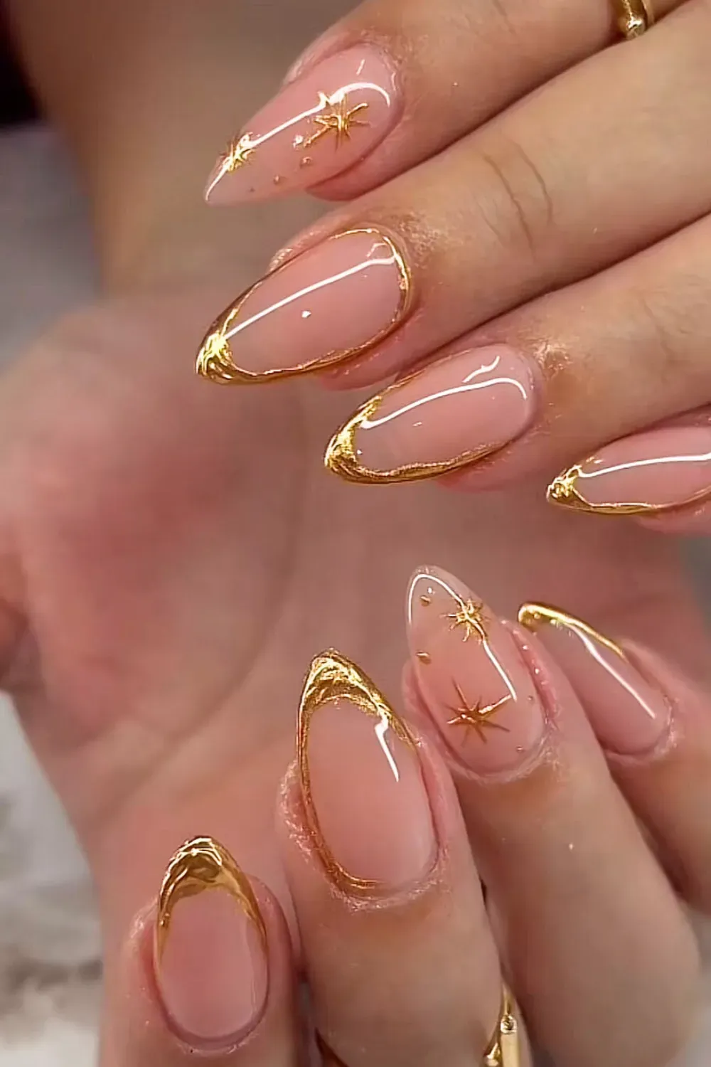 Long nude nails with 3D chrome gold drip French tips.