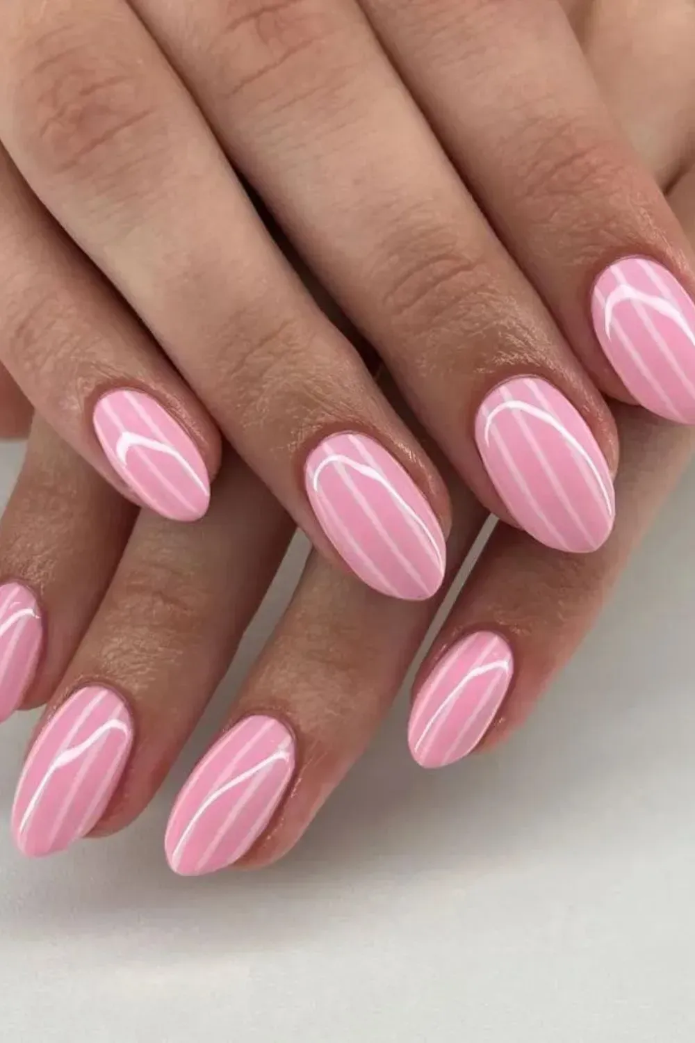 Pink Candy Stripe Nails - Pink almond nails with vertical candy stripes for a retro vibe