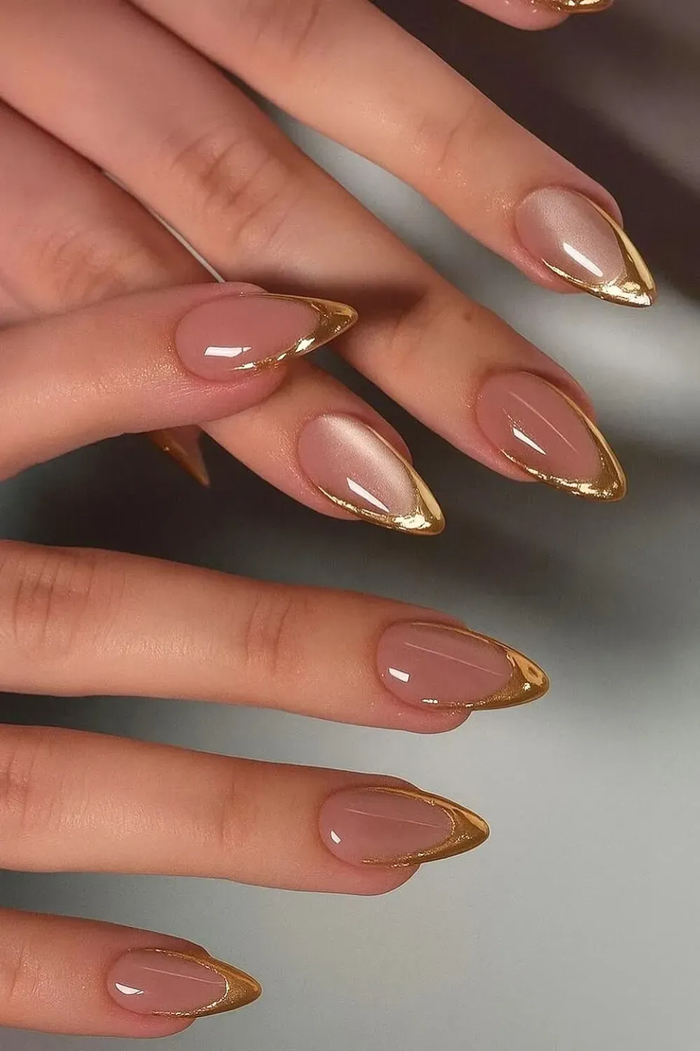 Almond nails with gold V-tip design