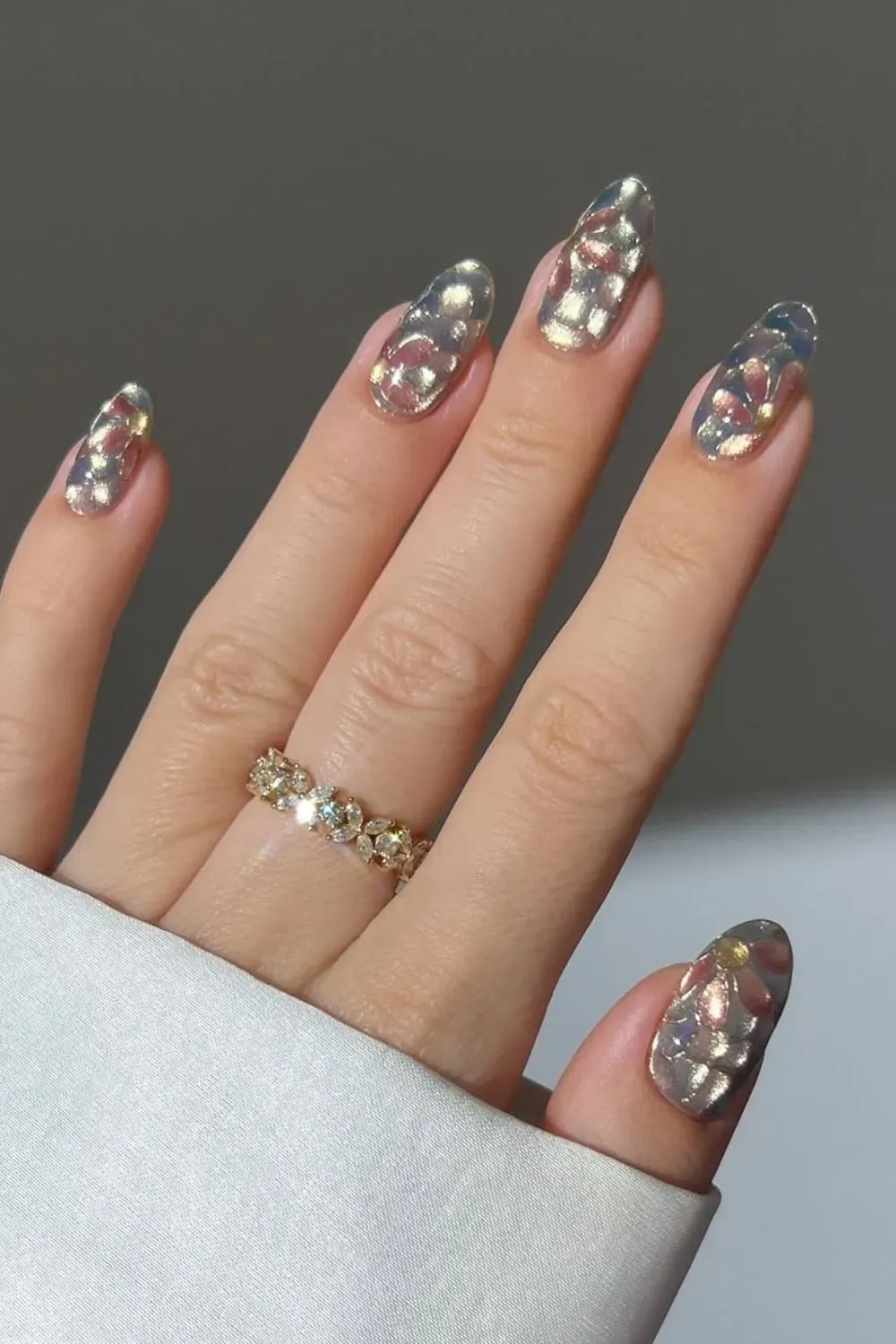 Shiny chrome nails with floral accents and multidimensional shine.