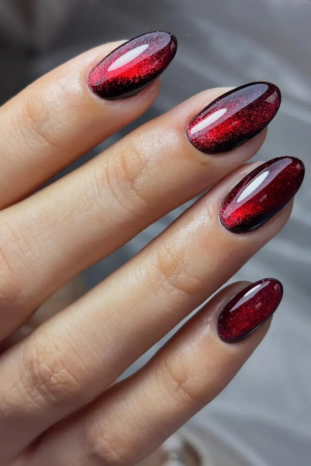 High-gloss, dark cherry red cat eye nails with a strong magnetic shimmer stripe.