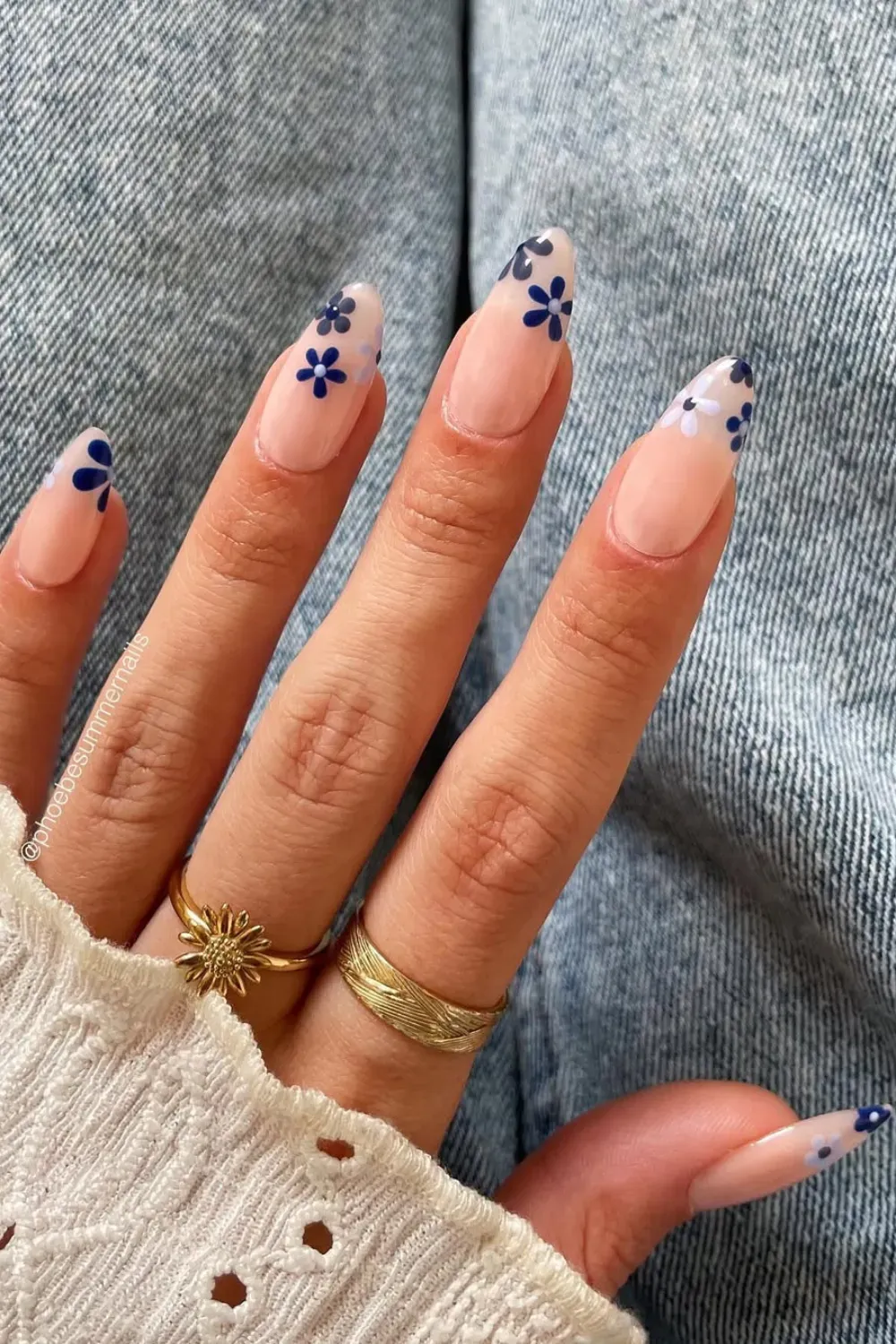 Delicate Blue Floral Accent Sheer Nails Long oval nails with a sheer nude base, adorned with small, delicate dark blue floral designs at the tips.