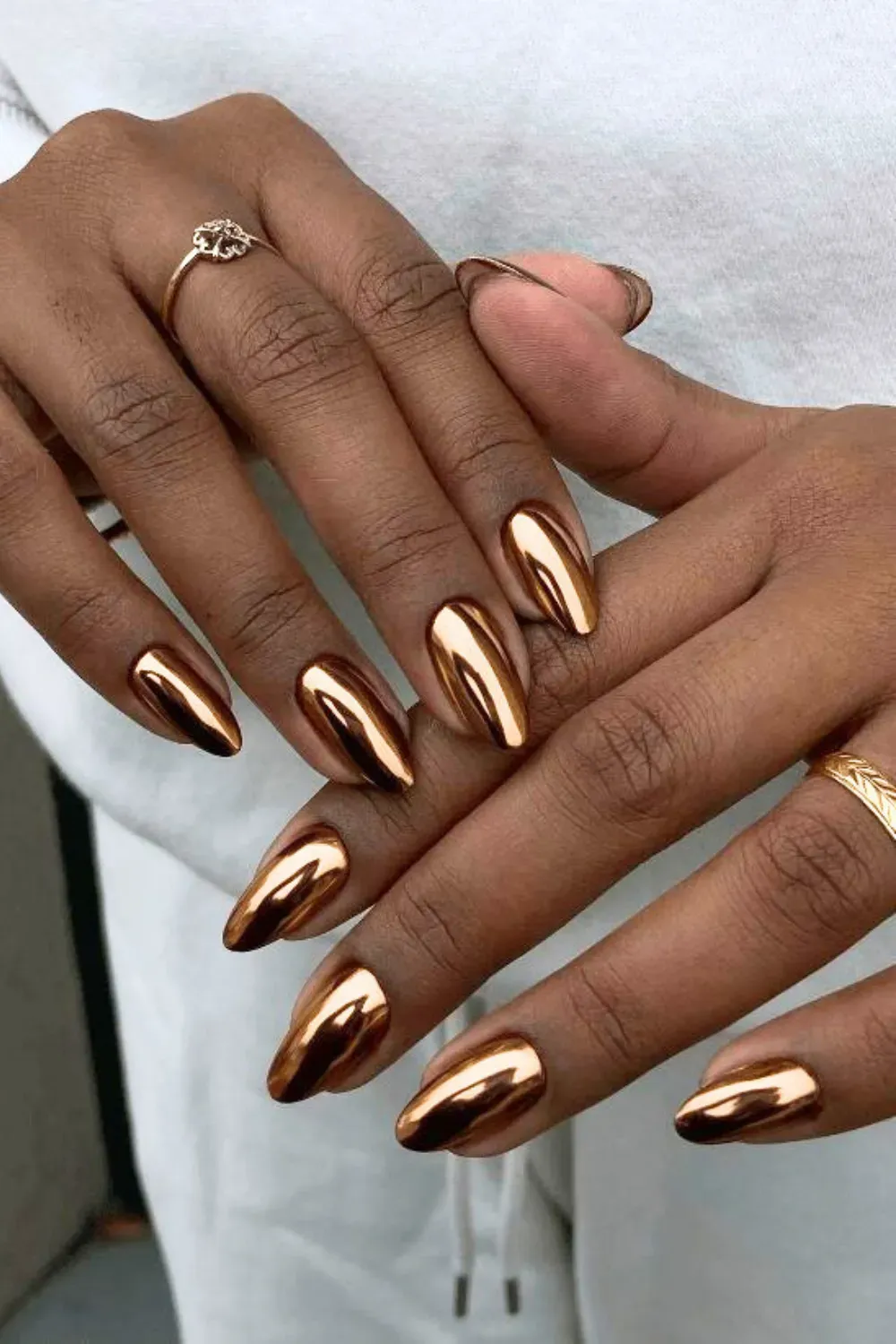Almond nails with a flawless copper-gold chrome finish.