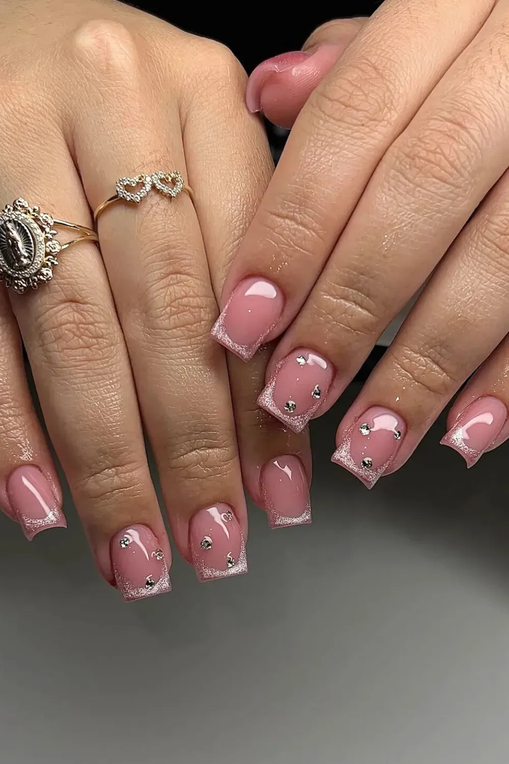 Short square nails with a pink glitter cateye French tip and scattered silver rhinestones.