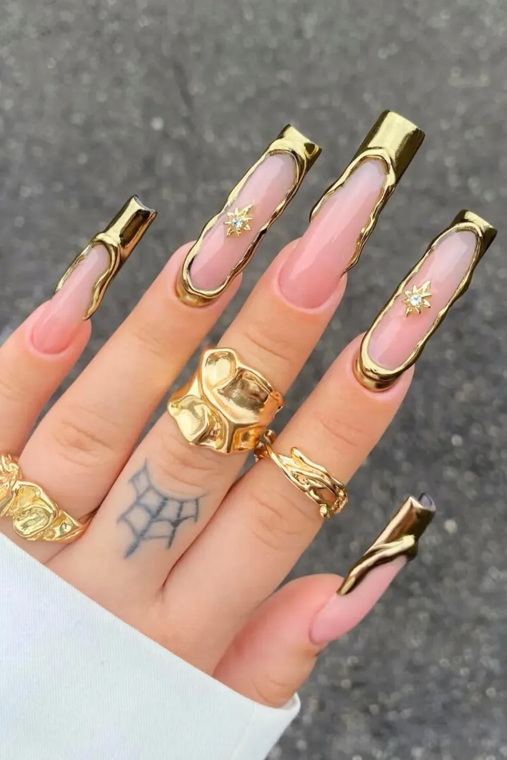 Extra-long coffin nails with gold glitter and gemstone tips.