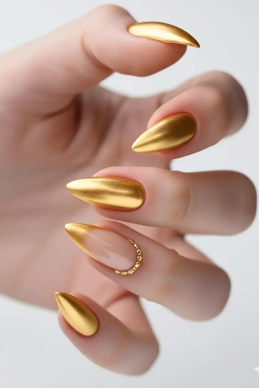 Long almond nails with gold chrome and glitter V-tips.