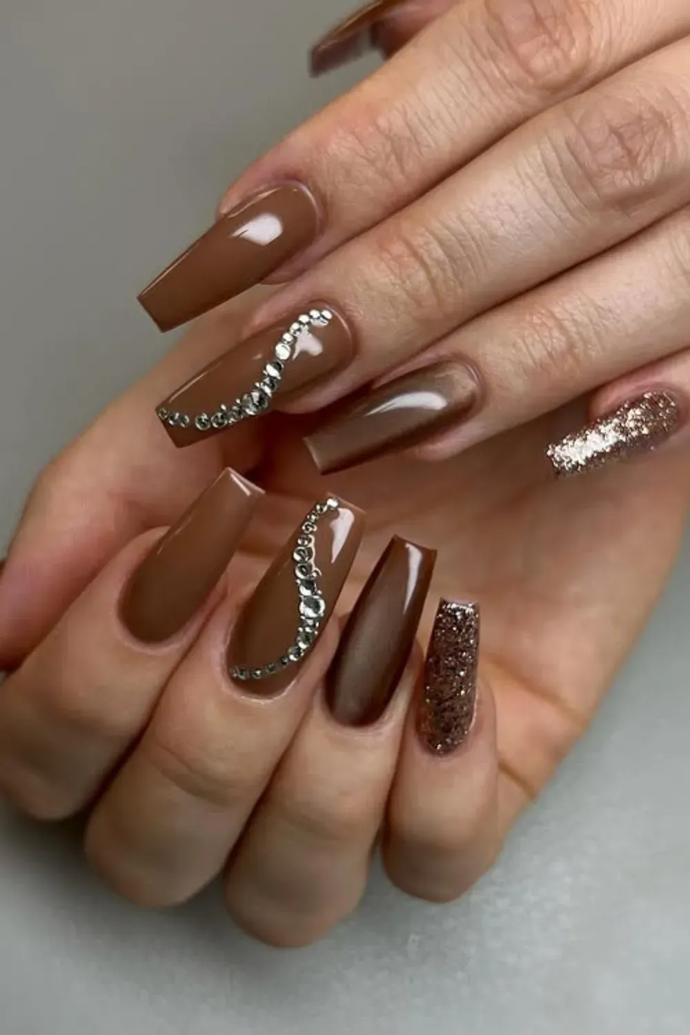 Mocha Coffin Nails with Rhinestones - Long coffin nails in chocolate brown/mocha mousse shade, featuring a glitter accent nail and an elegant curving line of silver rhinestones.