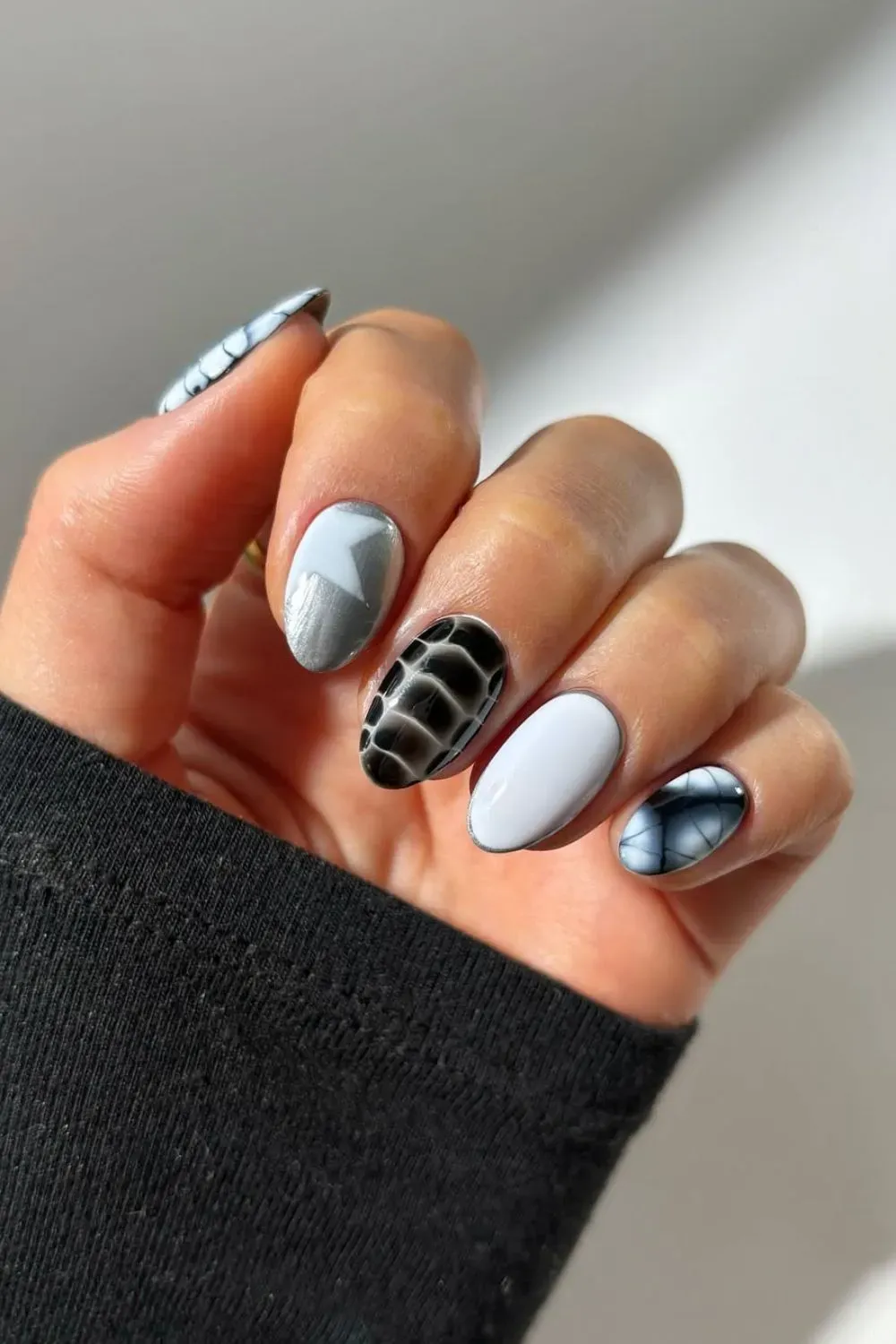 Black and silver graphic nails with croc-skin and icy accents.