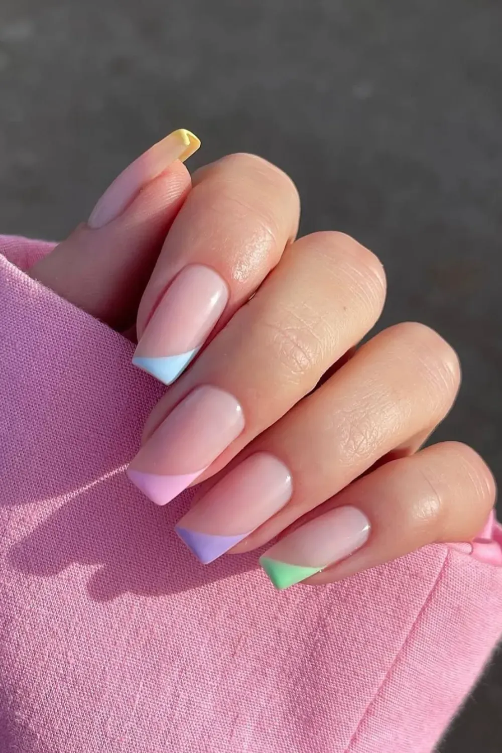 Pastel Color-Block French Tips - Long square nails with a nude base and diagonally color-blocked tips in pastel pink, purple, mint green, and yellow.