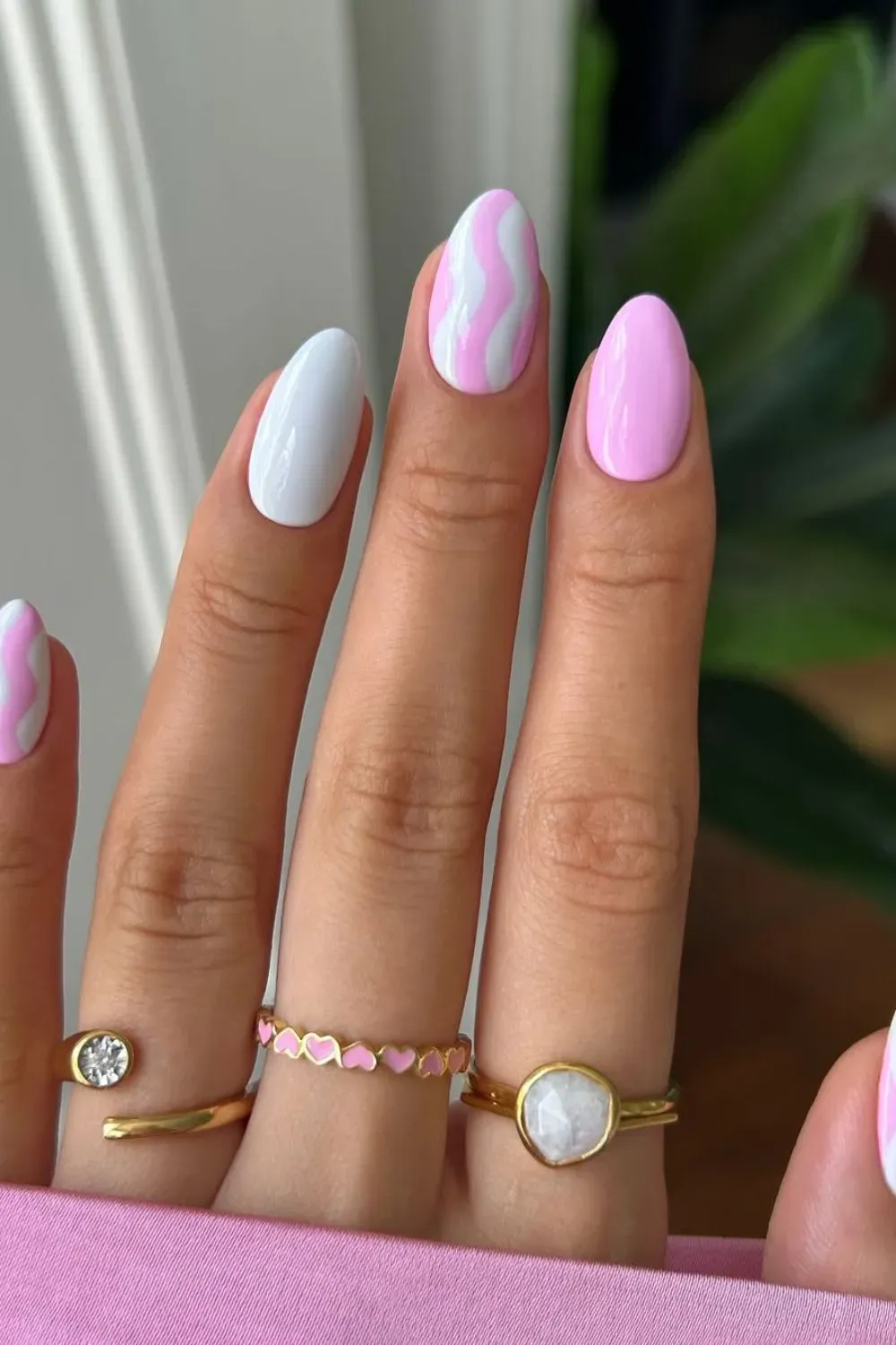 Pink and white wavy pastel nail design on a glossy base.