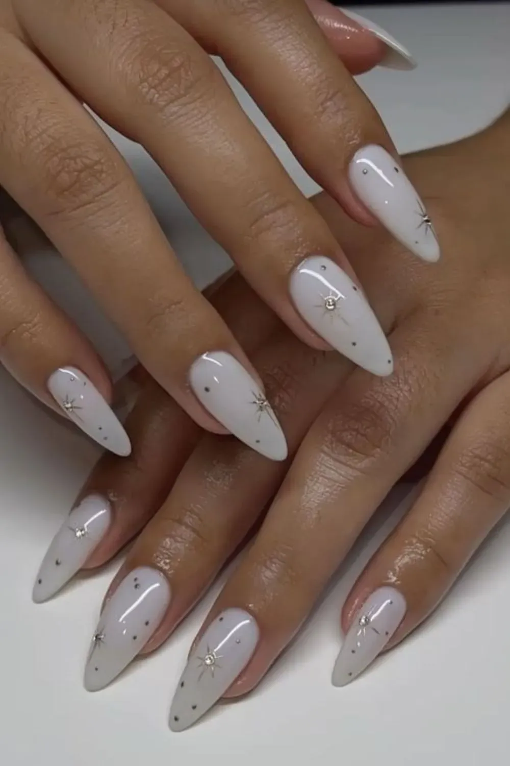 White Starburst Nail Art - White almond nails with delicate starburst and dot accents
