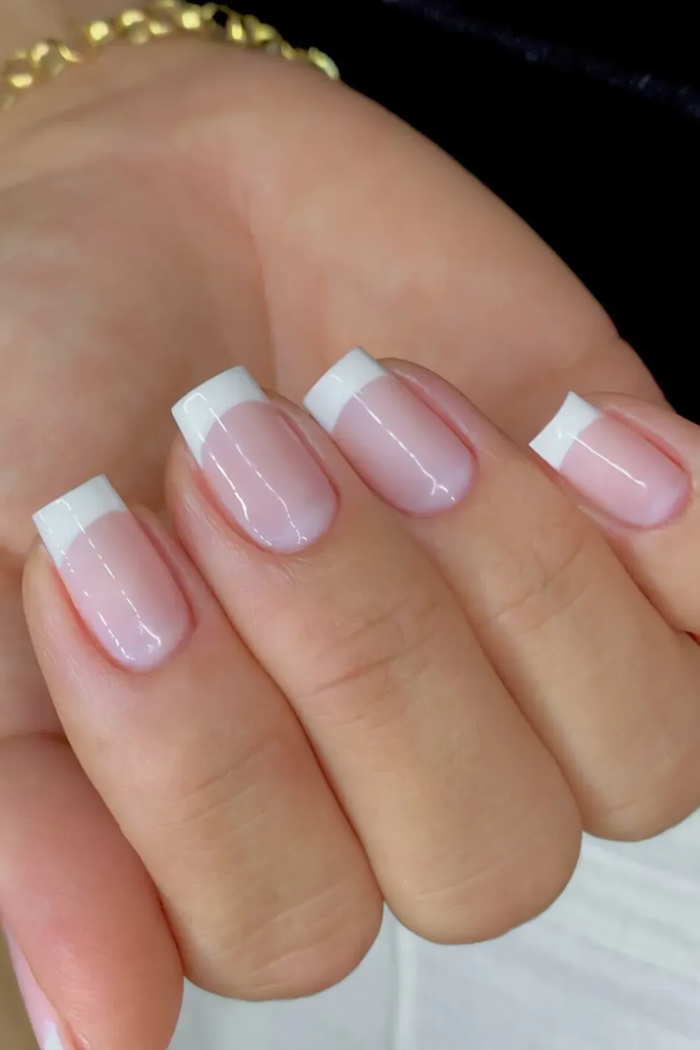 Short square nails with a milky pink base and a crisp, opaque white French tip.