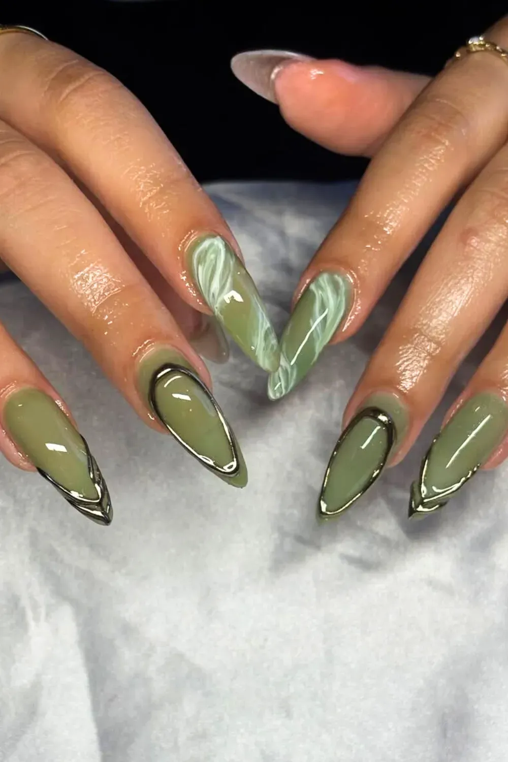 Opulent Jade Marble Stiletto Nails with Gold Frame - Long, sharp stiletto nails featuring deep jade green, white marble, and sharp metallic gold framing.